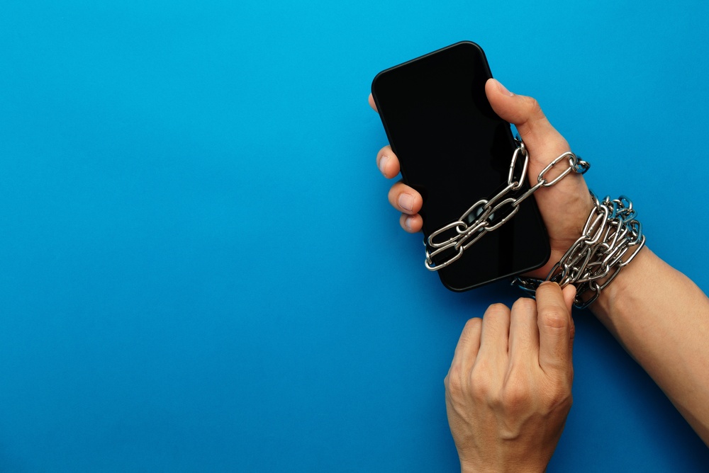 Hand,Chained,To,A,Smartphone,Symbolizes,Extreme,Digital,Addiction,,Technology